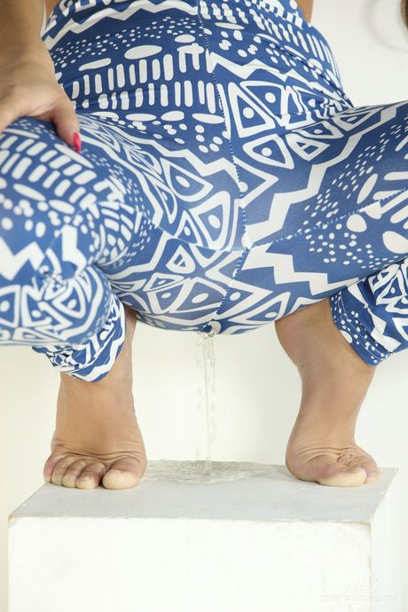 Slim teen Frida takes a piss after getting naked in a pair of yoga pants