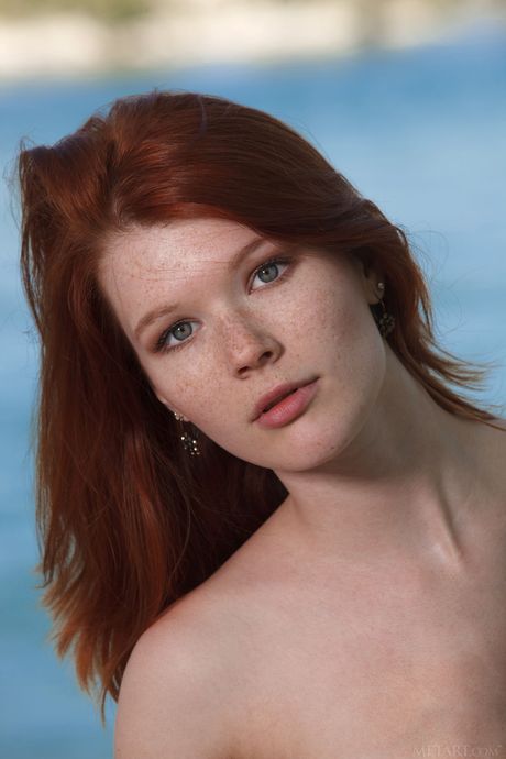 Teen dai capelli rossi Mia Sollis si nutre su un molo con i tacchi alti
