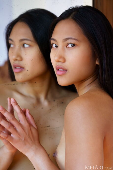 Asian teen May Thai removes her bra and panties to pose nude in her bedroom