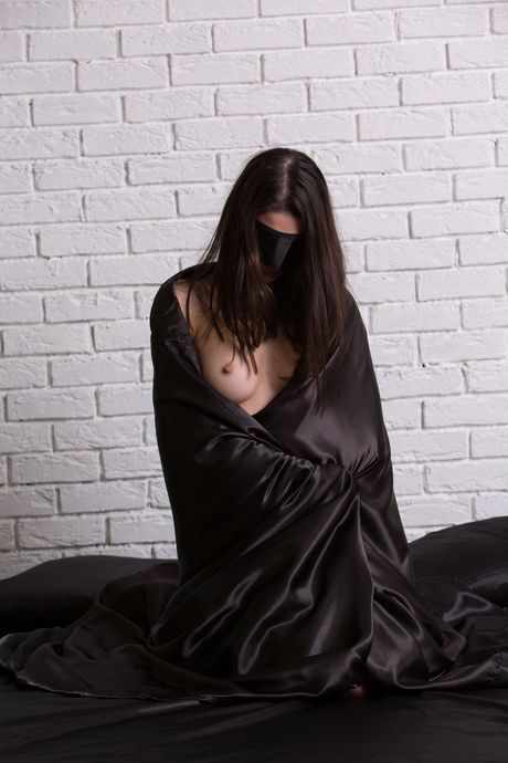 Abigail A takes off her sexy lingerie and stockings to pose nude on the bed