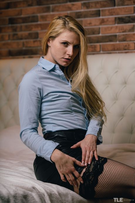 Blonde teen Jade removes a leather skirt before masturbating in fishnets