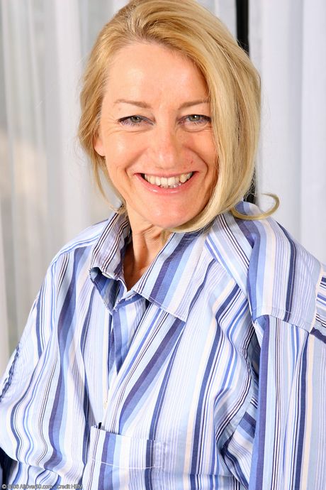 Mature blonde Robin strips and massages her pussy while doing housework