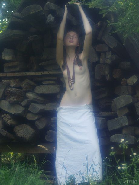 Attraktiv tonåring med små tuttar Katya B poserar naken utomhus i ett fält
