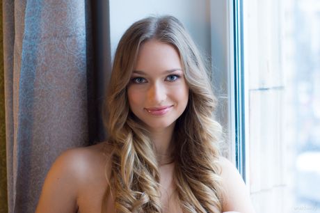 Sweet Ukrainian babe Amy Moore poses totally naked in front of a window