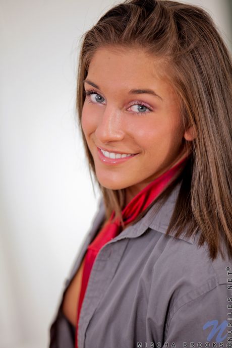 College girl with long hair and a perfect ass fingers her pussy on a bed