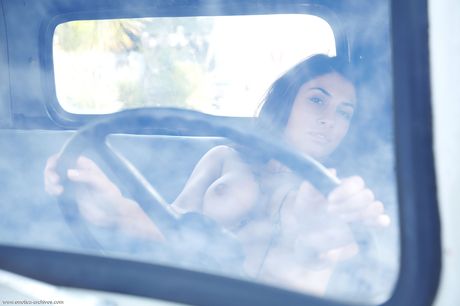 Nadia poses in the car as she presents her sexy body and shaved pussy