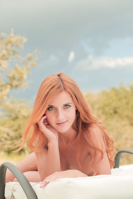 Skinny redhead Roberta Berti removes her bikini to pose nude in the sun