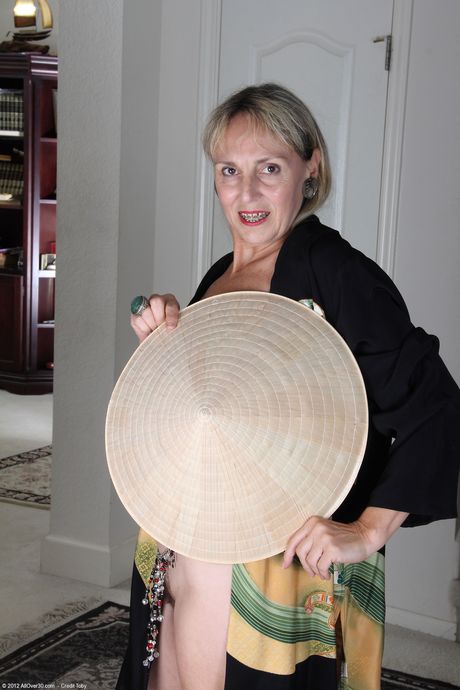 Mature woman Sienna strips off her uniform to show her bushy vagina