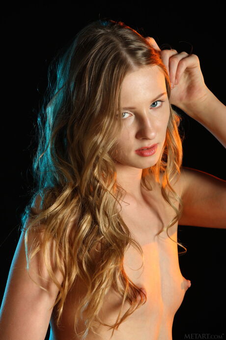 A adolescente loira magna Nimfa remove sua lingerie e meias para posar nua
