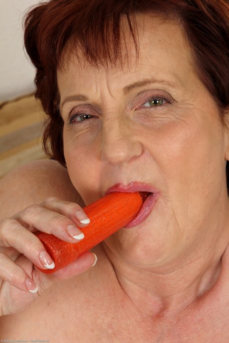 Redheaded granny Hillary G toys her pussy with a dildo in a solo