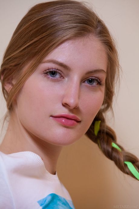 Cute teen Bretona removes her pigtails and panties to pose nude on a couch