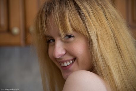 Blonde teen Eava removes a thong to pose nude in her kitchen