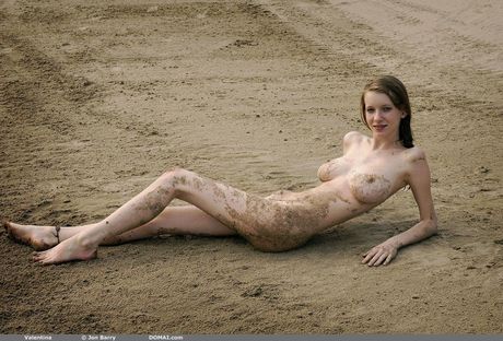 Young blonde Valentina models totally naked on a sandy beach