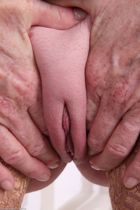 Redheaded granny Tami Estelle shows her saggy tits and poses in stockings