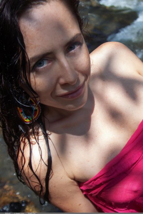 Adorable teen Madivya models totally naked in a shallow pool of water