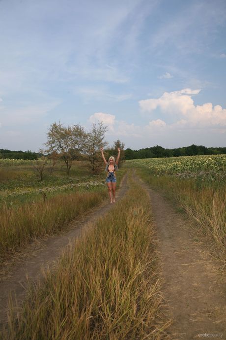 Young blonde Rina D bares herself on a blanket in the backyard