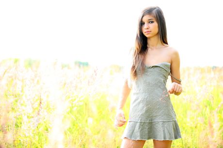 Adorable teen Nika removes a dress to pose nude on a patch of grass