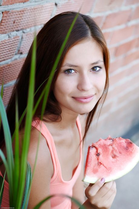 Perfect teen Afrodita gets naked in a backyard pool and shows her bald pussy