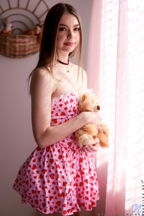 Nubiles: 甜美少女 Sylvie Sterling 在床上用手指涂抹粉红色的阴部