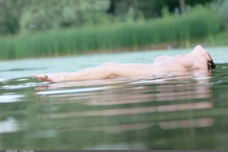 젖은 비키니를 입은 마른 올가 C가 해변에서 알몸으로 섹시한 엉덩이를 보여주는 포즈를 취하고 있습니다.
