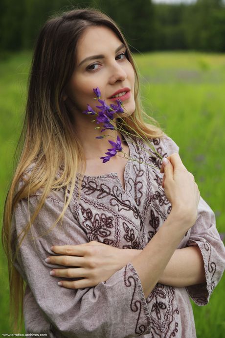 Blonde teen Kira bares her body in a field of wildflowers during solo action