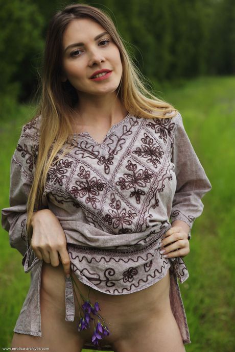 Blonde teen Kira bares her body in a field of wildflowers during solo action