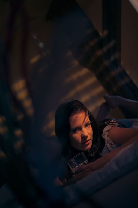 Thin teen Leony April bares her body before fingering her pussy on a bed