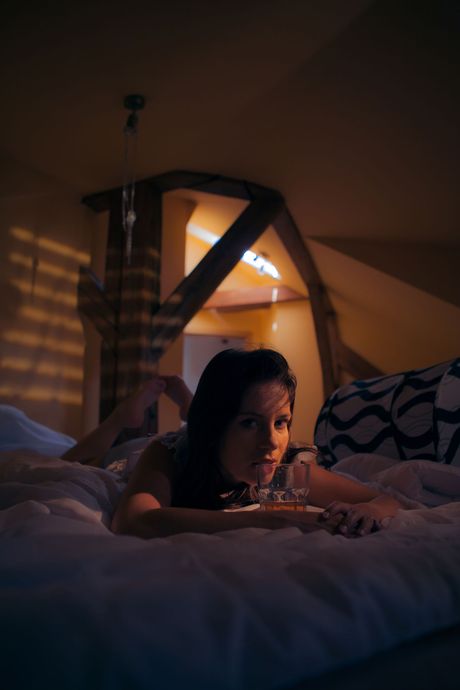 Thin teen Leony April bares her body before fingering her pussy on a bed