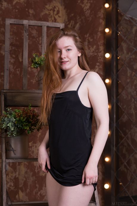 Sexet rødhåret Anicka fjerner en sort kjole for at udgøre nøgen på en stige
