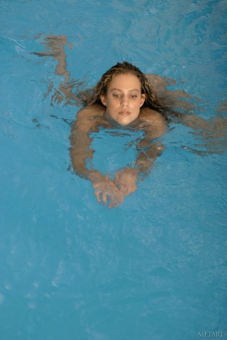 Adolescente loira Betty A remove seu biquíni e calcinha para posar nu em uma piscina
