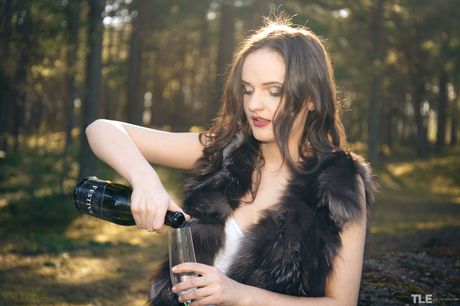 Maria Z strips outdoors and plays with a bottle in the woods