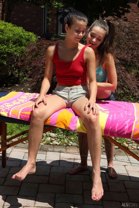 Teen lesbians Alaina Kristar & Gia Paige finger pussies on a table out back