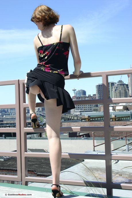 Young redhead Genevieve goes nude on a stool in a kitchen