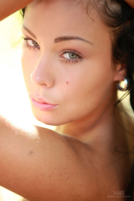 Dark haired teen Promise models totally naked in a forest by herself