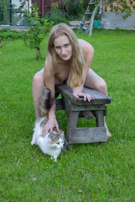 Svelte teen Leona shows her tiny tits and shaved pussy in the backyard