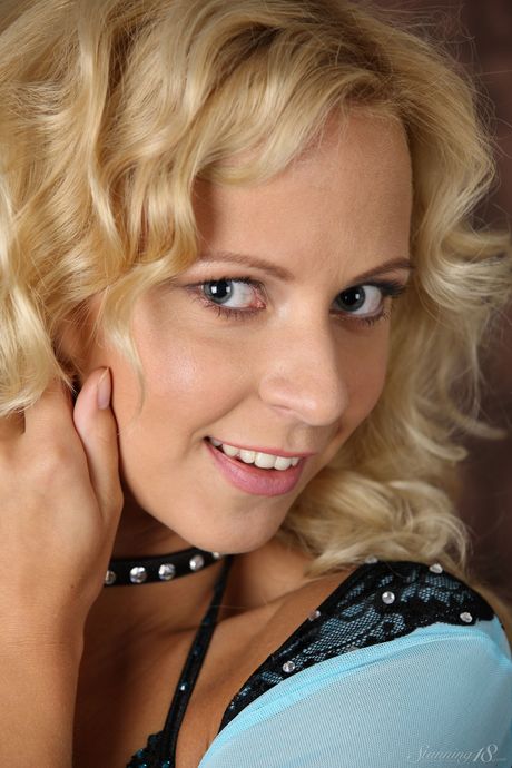 Blonde teen Hilary G removes a choker before getting naked in a bedroom