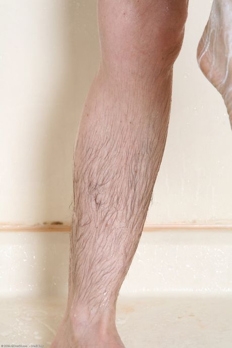 Mature woman Lacy washes her hairy pussy and shaves her legs in a shower