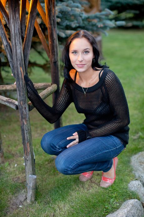 Teen Diana G de cabelos escuros fica nu em um campo de grama alta
