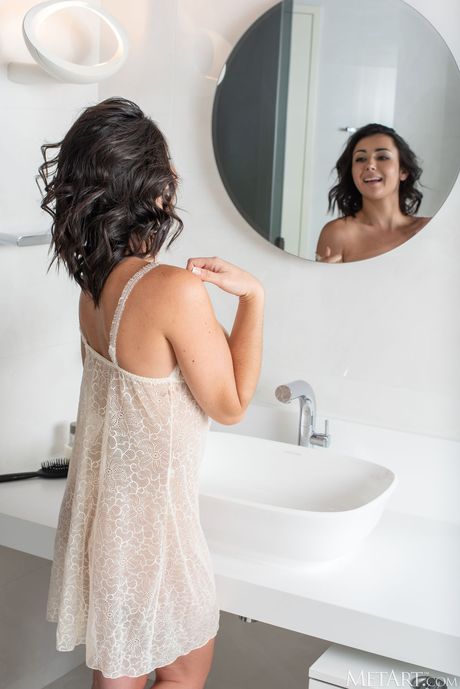 Bashful teen Dionisia removes a sheer nightgown to get naked in the bathroom