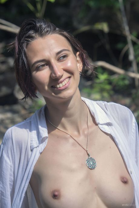 Hot brunette Alisa M reveals her big tits and poses naked in the water