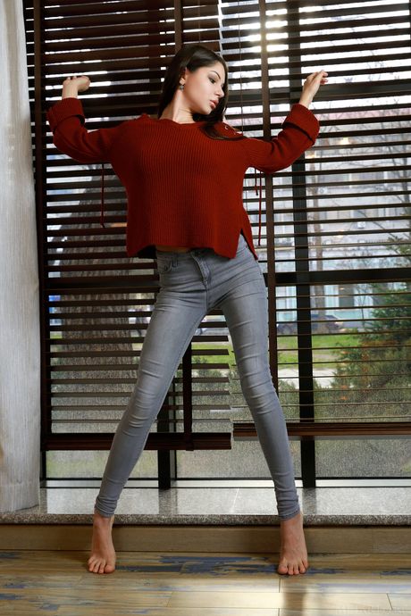 Tender teen Delphina removes her sweater and jeans to pose nude in her room