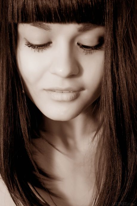 Dark haired teen Shereen A gets naked on a bed in an enticing manner