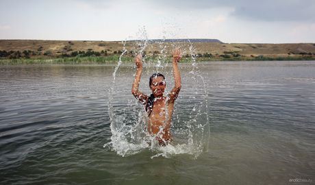 Slank tonåring ingaa blir naken i en grunt pool när han bär en bikini

