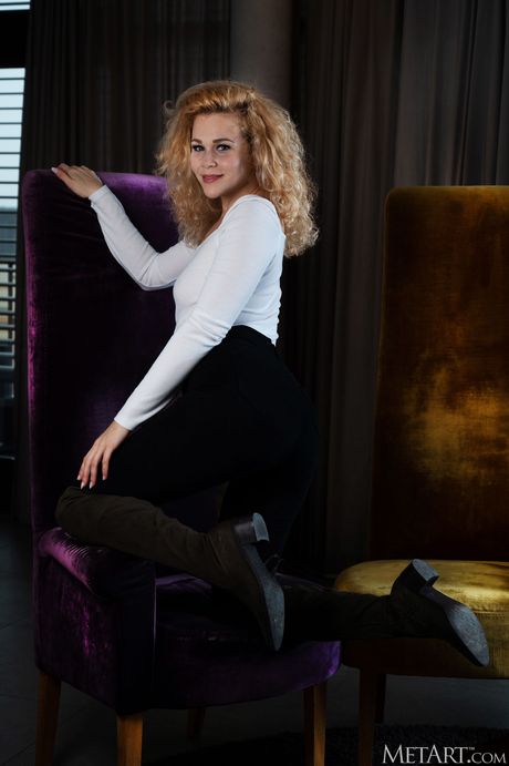 Ligh-haired teen Helena takes off everything on a chair in front of a fireplace