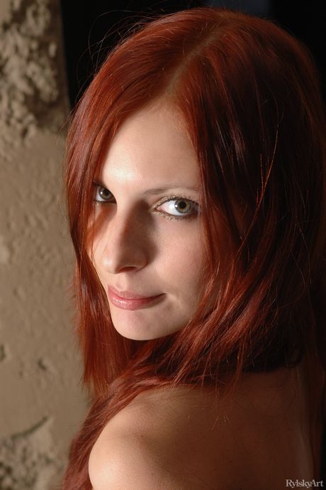 Young redhead Alyssa Flames gets naked in stockings and boots