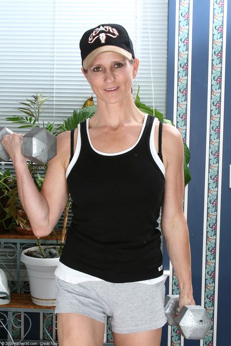 Mature woman Veronica B shows her big ass and tits while wearing a uniform