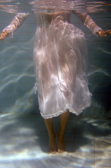 Sexy redhead Katerina C gets naked in a pool while wearing a bikini