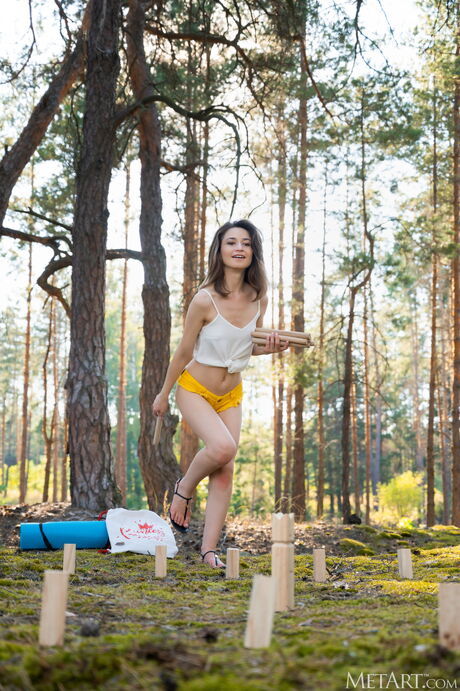 Charming teen Susie bares her body while playing with a ball in the wilderness