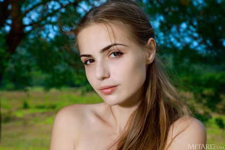 La delgada adolescente Elle Tan se desnuda totalmente en una manta en un campo
