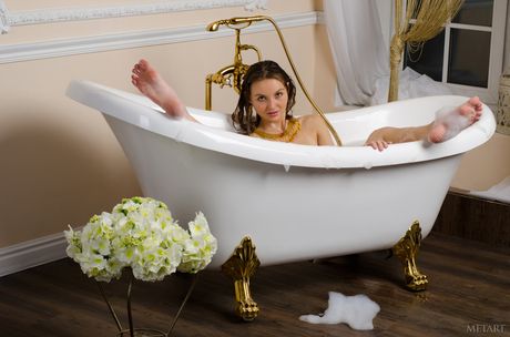 욕조에서 누드 포즈를 취하기 위해 목욕 가운을 벗는 금발의 십대 밀라그레스 A
